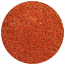 A close-up of a round pile of The Spice Lab All-Natural Taco Seasoning, a finely ground red-orange spice blend, on a white background.