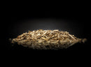 Napoleon Apple Wood Chips (67007) by Napoleon Grills are shown in a light brown pile on a reflective black surface, their texture and color highlighted—ideal for adding a mild smoke flavor to your barbecue.