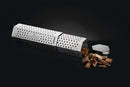The Napoleon Travel Smoker Tube (67075) by Napoleon Grills, with a perforated stainless steel design and removable lid, is pictured on a dark background, partially open with wood chips spilling out.
