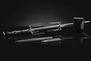 The Napoleon Grills Commercial Grade Rotisserie Kit (69241) for PRO Charcoal Kettle 22" and 18" grills, featuring skewers, adjustable forks, and a powerful motor, is shown on a reflective black surface against a dark background.