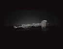 A Napoleon Grills Commercial Grade Rotisserie Kit for Charcoal PRO Grill PRO605CSS (69331) is displayed horizontally on a reflective black surface, resembling premium grill equipment, set against a dark background.