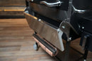 A stainless steel Pimp My Grill® Tactical Stainless Folding Front Shelf for the Recteq RT-590, serving as a convenient no-drill folding front shelf accessory.