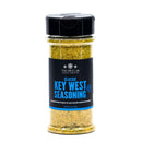 A clear spice jar from The Spice Lab Seafood Seasoning Set, labeled “Key West Seasoning,” features a black lid and blue text. The jar contains a yellowish seafood spice blend—perfect for seasoning salmon or adding flavor to seafood boils. The label also includes “The Spice Lab” and “Cooking Inspiration.”.