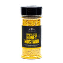 A clear spice jar labeled The Spice Lab Country Style Honey Mustard Seasoning displays the vibrant yellow blend inside and features a black cap—ideal for infusing your favorite BBQ dishes with a tangy, flavorful twist.