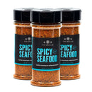 Three bottles of The Spice Lab Spicy Seafood Seasoning are arranged side by side, each with a black lid and a blue label displaying the product name. This blend from The Spice Lab is ideal for coastal dishes, delivering Cajun-inspired heat to enhance your favorite seafood recipes.