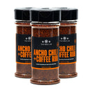 Three bottles of The Spice Lab Ancho Chili + Coffee Rub are arranged in a triangle on a white background. Each bottle features a black cap and a sleek black label with bold orange and white text, making this seasoning both visually striking and ideal for professional kitchens or grilling enthusiasts.
