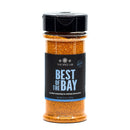 A clear plastic jar with a black lid labeled The Spice Lab Best of the Bay Seasoning, containing 6.4 oz (181g) of vibrant orange-red blend packed with coastal flavors and the signature warmth of smoked paprika.