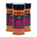Three bottles of The Spice Lab All-Natural Taco Seasoning by The Spice Lab are grouped together, each featuring a black label with pink text. This reddish-brown premium seasoning is designed for use in tacos, chili, soups, and stews.