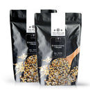 Two black resealable bags labeled The Spice Lab Everything and More Seasoning, an all-purpose blend featuring savory garlic and onion, are displayed with a wooden spoon scooping the flavorful mixture in front of each bag.