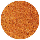 A close-up, top-down view of a circular mound of The Spice Lab Shrimp + Crab Boil Seasoning by The Spice Lab, featuring fine, reddish-orange granules with a textured appearance on a white background, showcasing the vibrant color and medium heat characteristic of classic shrimp and crab boil blends.