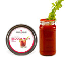 A mason jar filled with a savory Bloody Mary cocktail garnished with celery sits next to a tin labeled The Spice Lab Bloody Mary Salt Cocktail Rimmer, featuring an image of the cocktail on the lid.