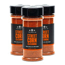 Three bottles of The Spice Lab Mexican Street Corn Seasoning, each featuring a vibrant orange label, are displayed in a triangular formation on a white background. This zesty seasoning from The Spice Lab brings authentic elote flavor to your favorite dishes, from grilled corn to taco blends.