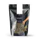 A black resealable bag of The Spice Lab Chimichurri Seasoning, with a wooden spoon scooping up the dried herbs and spices, labeled No. 7146 and Net Wt. 2 lb. on the front.