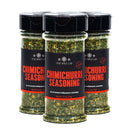 Three bottles of The Spice Lab Chimichurri Seasoning, each containing 2.5 oz, are displayed side by side with their clear plastic containers and black lids showing off the vibrant mixture of herbs and spices inside. This Argentine-style seasoning from The Spice Lab delivers bold flavor and an authentic touch of South American zest to your kitchen.
