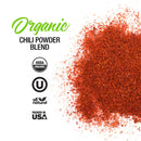 Loose chili powder is scattered on a white background. Text reads: The Spice Lab Organic Chili Powder Blend with USDA Organic, Kosher, All Natural, and Packed in USA certifications in black and green—perfect as an organic chili powder from The Spice Lab for your favorite Tex-Mex seasoning recipes.