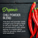 Three red chili peppers rest on a dark wooden surface next to text highlighting The Spice Lab Organic Chili Powder Blend by The Spice Lab—an essential ingredient for authentic Tex-Mex seasoning renowned for its versatile culinary uses.