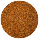A close-up of a circular pile of reddish-brown The Spice Lab Rotisserie Chicken Seasoning with visible granules and herbs, showcasing its golden color, displayed on a white background.