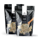Two black pouches of The Spice Lab Three Onion Blend, both featuring the savory onion flavor of this signature seasoning, each with a clear window displaying chopped dried onions. A wooden spoon scoops up the delicious blend. The packages are labeled No. 7197 Net Wt. 2 LB and are produced by The Spice Lab.