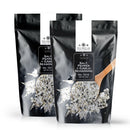 Two black pouches of The Spice Lab Salt, Pepper + Garlic Seasoning by The Spice Lab, labeled No. 7216, featuring a wooden spoon scooping the flavorful blend—ideal for grilling BBQ or enhancing your everyday cooking.