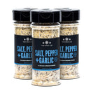 Three bottles of The Spice Lab Salt, Pepper + Garlic Seasoning by The Spice Lab, featuring black lids and blue labels, are arranged in a triangular formation on a white background—an ideal everyday cooking seasoning.