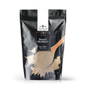 A black resealable pouch labeled The Spice Lab Night Market Seasoning sits beside a wooden spoon filled with light brown spices, some of which are spilled around. The packaging displays The Spice Lab logo and notes an 8 oz net weight. This Asian salt and pepper blend is perfect for infusing your dishes with the bold, vibrant flavors reminiscent of night market street food.