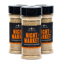 Three bottles of The Spice Lab Night Market Seasoning by The Spice Lab, inspired by lively Asian salt and pepper blends and described as ideal for meat, fish, and poultry, are grouped together on a white background.
