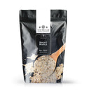 A black resealable bag from The Spice Lab, labeled “Smoky Maple Seasoning,” features a white label and an image of a wooden spoon holding a blend of spices on the front. The bag contains 2 pounds of this sweet and savory seasoning.