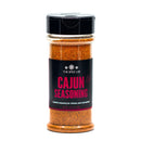 A clear plastic bottle of The Spice Lab Cajun Seasoning with a black lid and black label featuring red text. The label highlights that this seasoning is ideal for chicken, pork, and seafood, offering authentic Louisiana-style flavor with mild heat in every sprinkle.
