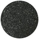Close-up view of coarse, black grains resembling sand or crushed minerals—such as The Spice Lab Black Steak Seasoning by The Spice Lab, which features activated charcoal—shown inside a circular frame on a white background. The distinctive texture and deep hue evoke a bold, savory steakhouse flavor.