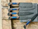 The Texan Knives Handmade Damascus Steel Chef Knife Set features five elegant hammered black blades with wooden handles and blue resin accents—an ideal Valentine’s or wedding gift for cooking enthusiasts.