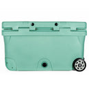 A front view of the Bob The Cooler Co. 75QT / 70.97L "BFF" Hard Cooler by Bob - The Cooler Co., featuring a large teal body, extra thick insulated walls, a handle slot, a black drain plug, and two heavy-duty black and white wheels on the right side.