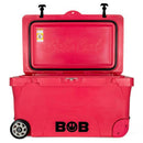 A large red Bob The Cooler Co. 75QT / 70.97L "BFF" Hard Cooler with heavy-duty wheels, featuring the "Bob" logo on the front, sits open with its lid raised. Inside, the words "Bobs Cool" are embossed, and extra-thick insulated walls are visible to keep contents cold for longer.