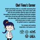 A cartoon chef with purple hair smiles next to text about using The Spice Lab Mediterranean Citrus Seasoning—a bright, herbal Greek-inspired flavor—on lamb, pita, or yogurt. Features icons for gluten-free, non-GMO, all-natural, and USA-made attributes, plus a web address for recipes. Set against a blue background.
