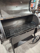 a large, black, metal grill with a metal grate on top, sitting on a metal stand.