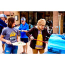 A woman uses the WPPO 7" Round Turning Pizza Peel With Break Down Handle by WPPO LLC Direct to place pizza in a blue outdoor oven, while another woman holds a plate of pizzas. Several people wait nearby, some serving themselves food.
