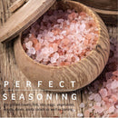 A wooden bowl filled with The Spice Lab Himalayan Pink Salt Coarse Grain, some crystals spilling out, with text saying PERFECT SEASONING and uses listed for meats, fish, vegetables, soups, stews, pasta salads, and baking—ideal for refilling your salt grinder and elevating every dish by The Spice Lab.