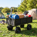A DirectDeals 880 lbs Utility Wagon Flatbed with Removable Oxford Cloth Liner, loaded with camping gear, sits on grass near tents and a campfire in a sunny outdoor setting.