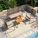 The DirectDeals 8-Piece Patio Conversation Set with Acacia Wood Coffee Table, featuring a cushioned bench and chairs, sits on a beige rug by the pool with flowers, coffee cups, and books on the table.