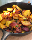 A cast iron skillet filled with sliced peaches and pecans sits on a wooden surface, the colorful fruit perfectly caramelized in the sunlight—as if just pulled from a WPPO LLC Direct 48" Professional Lava Digital Controlled Wood-Fired Oven With Convection Fan.