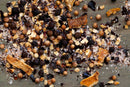 Scattered on a wooden surface, World Spice Bar-H Beef Rub by World Spice blends dried spices and herbs—such as coriander seeds, black peppercorns, dried orange peels, and coarse salt—for a classic steak seasoning that’s perfect for enhancing the flavor of your grilled dishes.