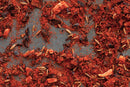 Close-up of World Spice New Mexico Chili Powder scattered on a surface, showcasing vibrant red chili powder accented with cumin seeds, dried chili pieces, and other seasonings from World Spice—perfect for adding bold flavor to your next batch of tacos or fajitas.