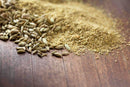 World Spice Fennel Seed, available as both whole seeds and ground powder from World Spice, scattered on a wooden surface—perfect for enhancing Indian curries or brewing a soothing digestive tea.