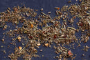 Loose, dried herbs and spices from World Spice are scattered on a dark surface, displaying a range of green, brown, and orange hues—perfectly combined as the World Spice Italian Sausage Mix for authentic sausage seasoning.