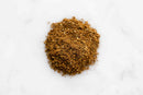 A small pile of World Spice Kofte Spice by World Spice sits on a white marble surface.