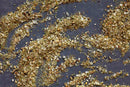 A close-up of World Spice Provençal Seasoned Salt and coarse sea salt from World Spice scattered across a dark gray surface, revealing an array of textures and colors—vivid green, yellow, and brown flecks—that capture the essence of French flavor.