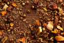 A close-up of World Spice Seattle Salmon Rub by World Spice, featuring a vibrant blend of whole coriander seeds, fennel seeds, roasted spices, dried orange peels for a citrusy note, and coarse salt, all scattered on a wooden surface.