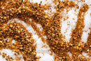 World Spice Smokin' Hot Garlic Pepper from World Spice is scattered in swirling patterns on a white surface, evoking the bold aroma of grill seasoning.
