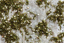 A close-up of World Spice Green Za'atar by World Spice, featuring vibrant green herbs, tangy sumac, and white sesame seeds scattered on a rustic wooden surface.