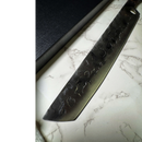 The Spaceman Knives Meteor Series Brisket Slicer—a large, hammered black chef’s knife perfect for BBQ and smoked meats—rests on white marble next to a black box.