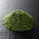 A small pile of The Spice Lab Dill Weed Whole by The Spice Lab sits on a dark, textured surface, showcasing this dried green herb as an ideal choice for bulk foodservice use.